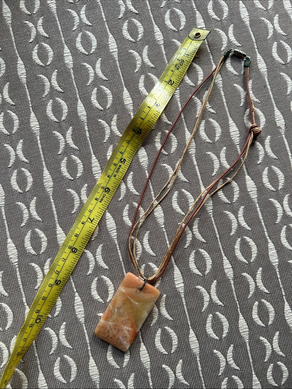 Natural stone necklace (stone is 2”) on a thin stranded set of natural strings